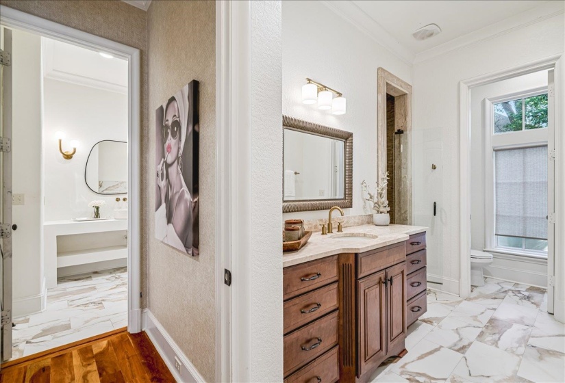 Bathroom featuring a wood vanity with a light-toned countertop, a shower enclosure with a glass door, and a toilet