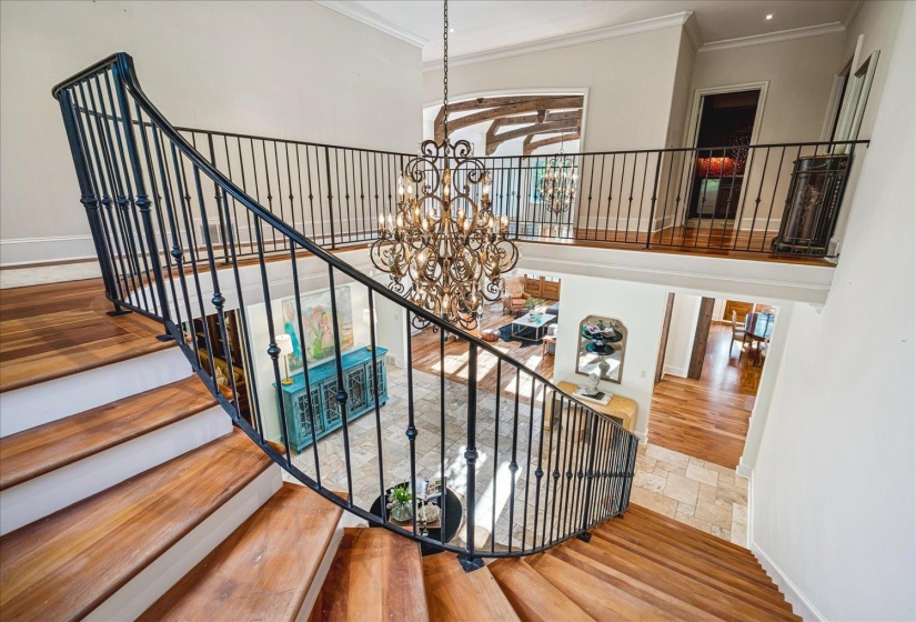 Grand entryway featuring a curved staircase with wood-finish treads and wrought iron balusters
