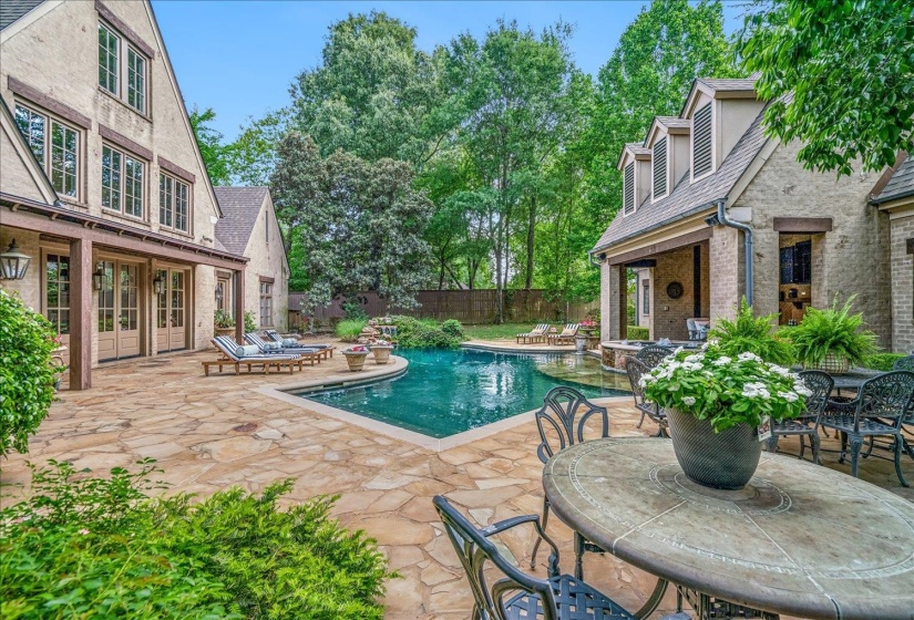 Expansive flagstone patio with a freeform swimming pool and multiple entertaining areas