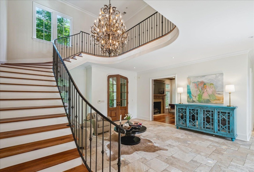 Two-story entryway featuring a grand curved staircase with wood treads and wrought iron balusters