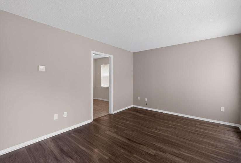 Empty room with dark wood finished floors and a textured ceiling