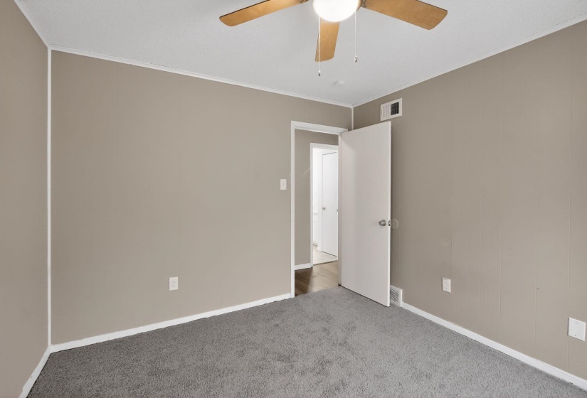 Carpeted spare room featuring ornamental molding and a ceiling fan