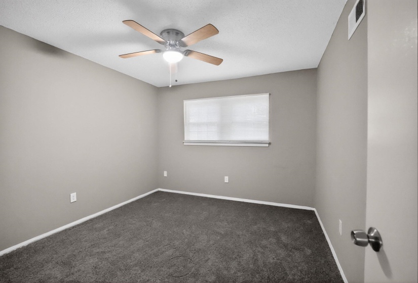 Unfurnished room with dark carpet and a ceiling fan