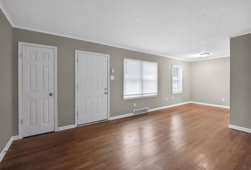 Entryway featuring crown molding and dark wood-style floors