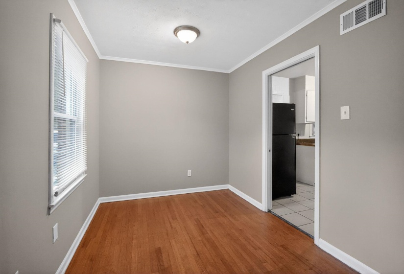 Empty room with ornamental molding and light wood-style flooring