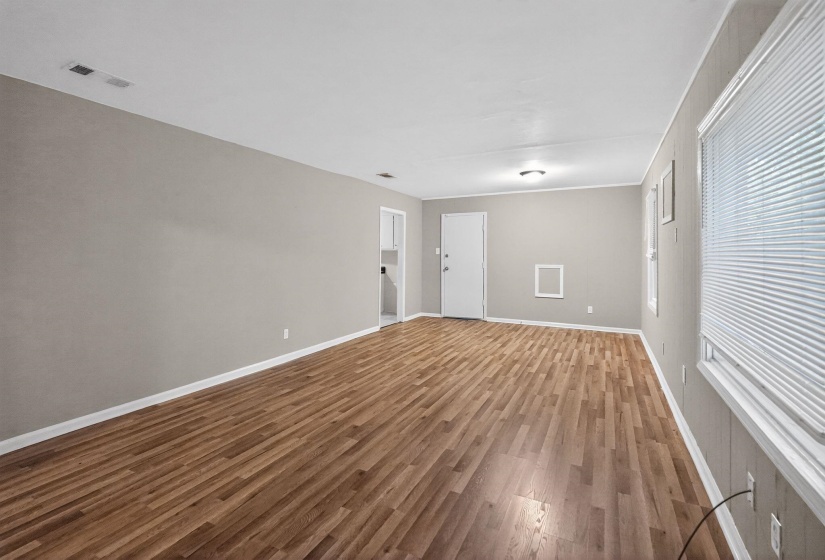 Spare room with dark wood-type flooring and baseboards