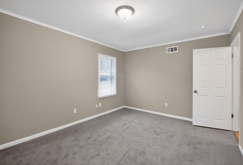 Spare room featuring carpet and crown molding
