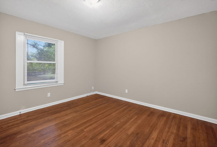 Empty room with dark wood finished floors and a textured ceiling
