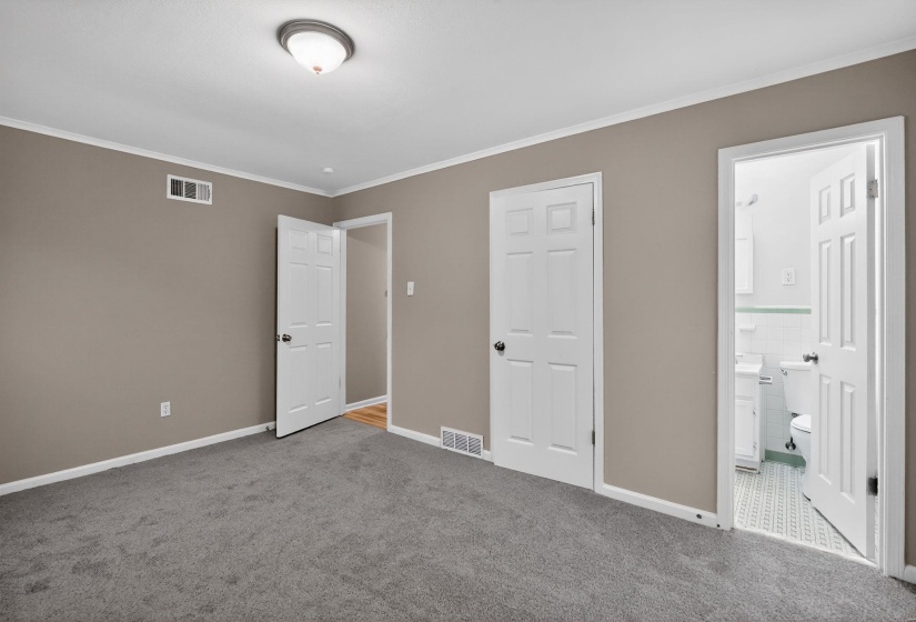 Unfurnished bedroom with carpet, ornamental molding, and connected bathroom