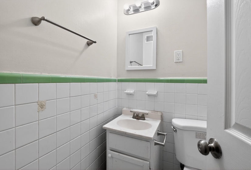 Bathroom featuring vanity, wainscoting, and tile walls