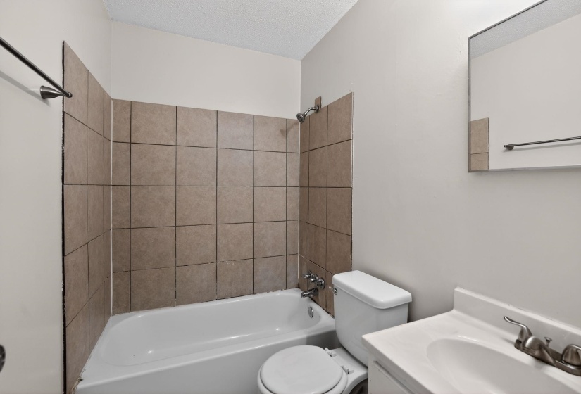Full bathroom featuring vanity, a textured ceiling, and bathtub / shower combination