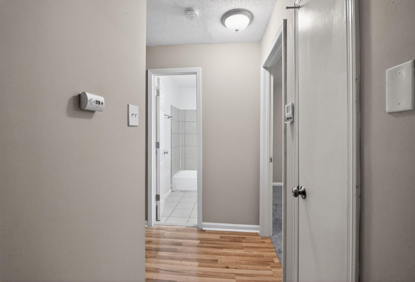 Hall with a textured ceiling and light wood finished floors