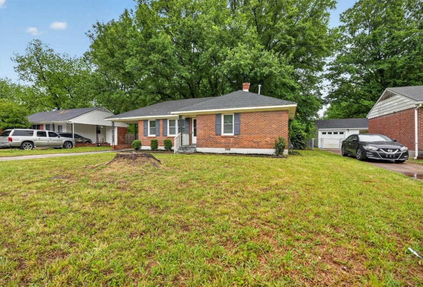 Ranch-style home with brick siding, a chimney, and a front lawn