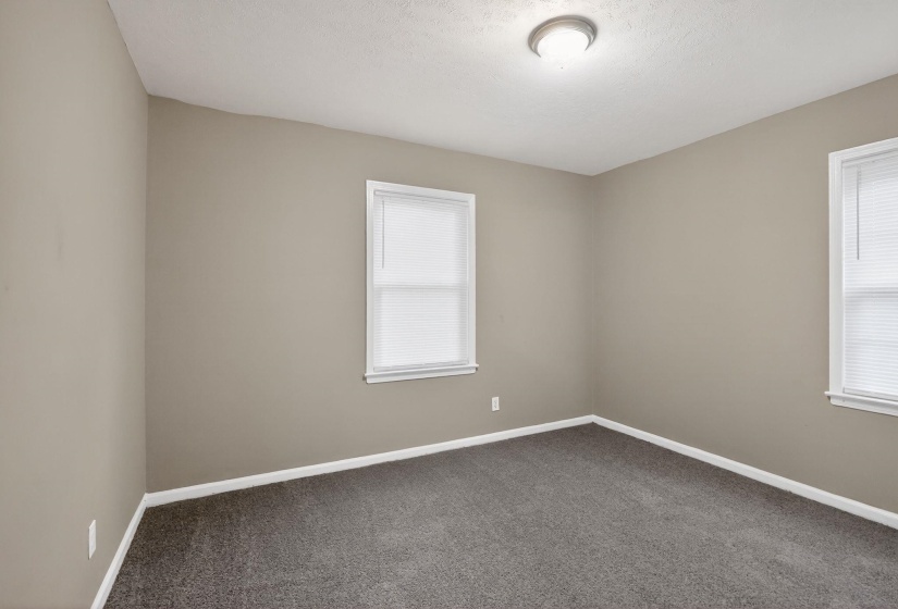 Neutral-toned walls complement the dark gray carpet flooring