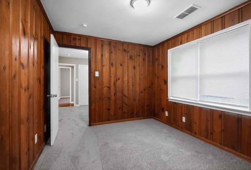Interior room featuring wood paneling, light gray carpeting, and a white ceiling