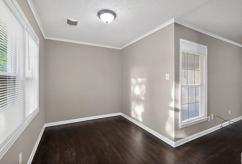 Interior space with dark wood-finish flooring, light grey walls, and white crown molding