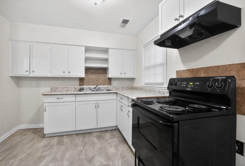 Kitchen featuring white cabinetry, a black electric range, and a coordinated range hood