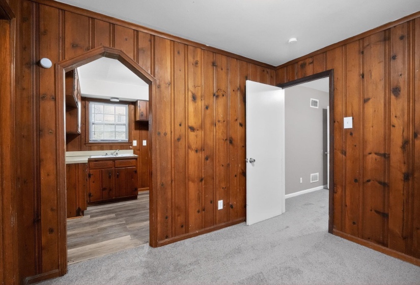 Interior room featuring wood paneling, light gray carpeting, and a white ceiling