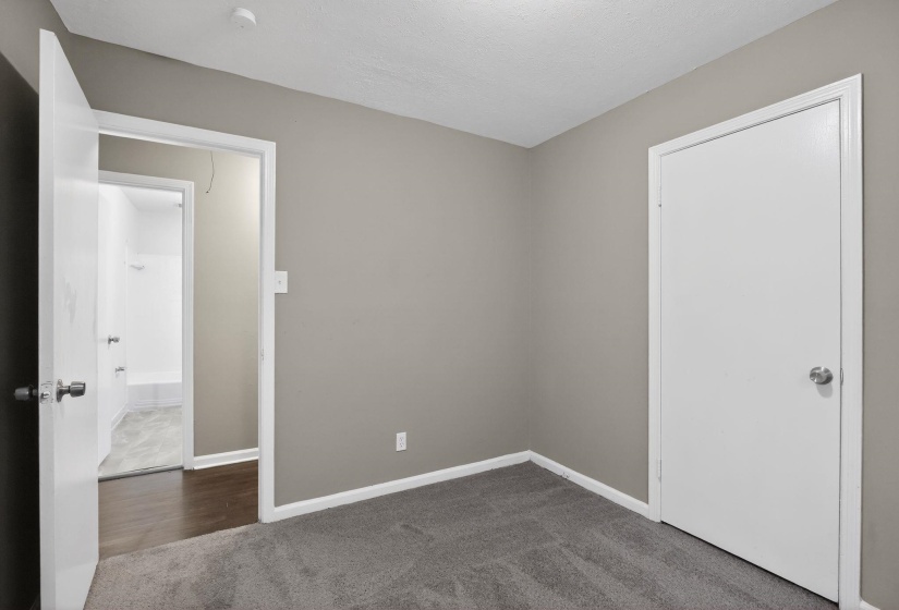 Bedroom featuring soft gray carpeting, neutral wall paint, and white trim
