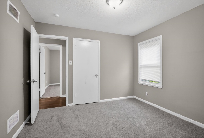 Carpeted interior room with neutral grey wall paint