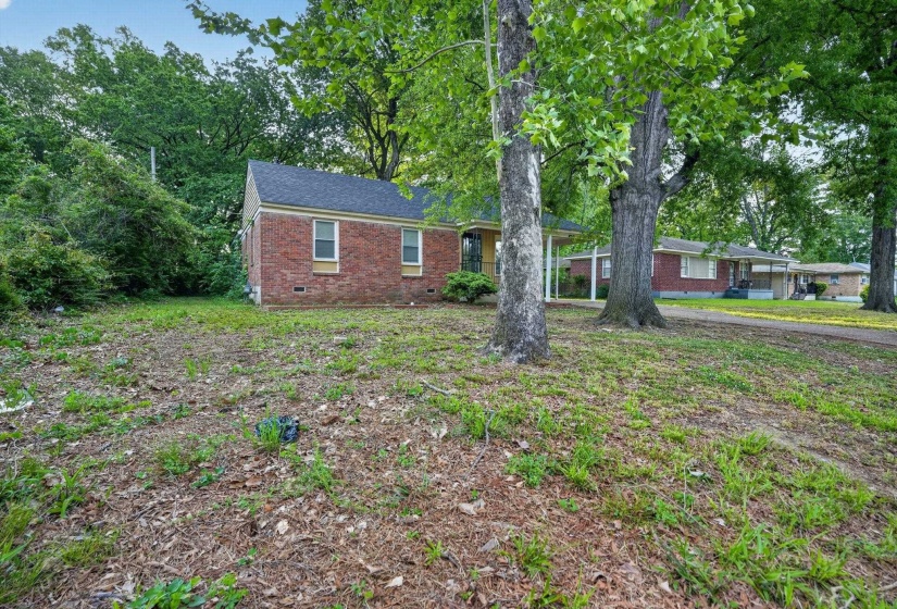 Brick exterior residence featuring a dark shingle roof and a covered entryway