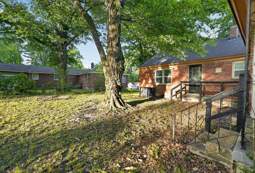 Brick exterior featuring multiple large windows and a covered porch with dark railings