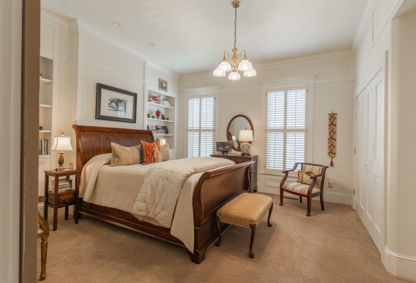 Carpeted bedroom featuring a closet, a chandelier, and ornamental molding