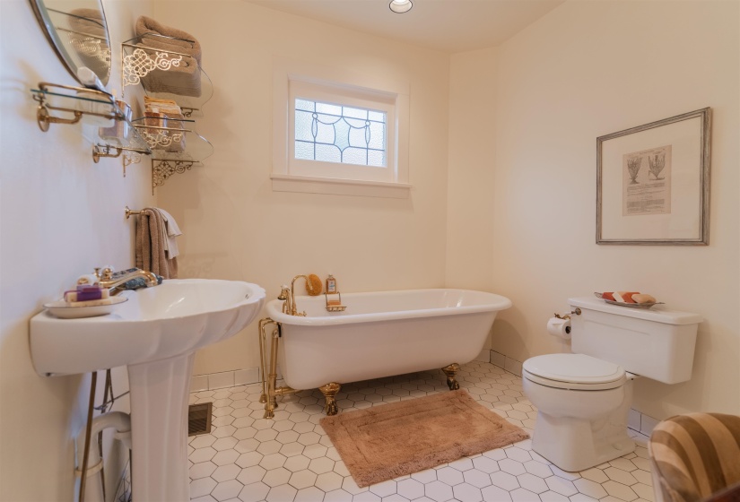 Bathroom with toilet, tile patterned floors, and a clawfoot bathtub. Brand new tub hardware