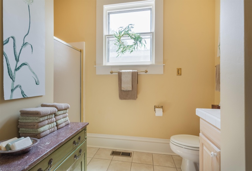 Bathroom with a shower with door, vanity, toilet, and tile patterned flooring