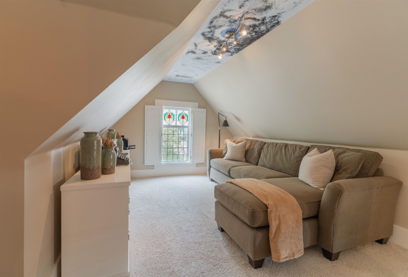 Carpeted living room featuring lofted ceiling