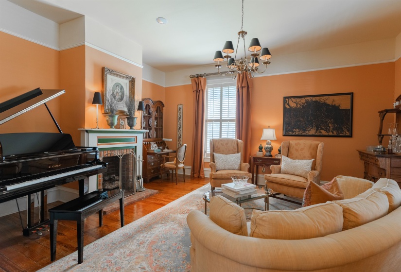 Living room featuring a brick fireplace, hardwood / wood-style floors, and an inviting chandelier