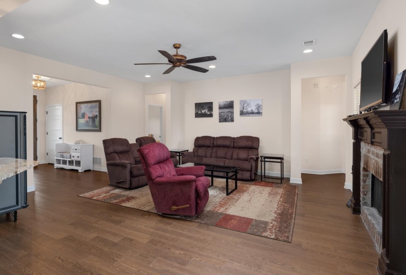 Spacious living area featuring wood-finish flooring, recessed lighting, and a ceiling fan