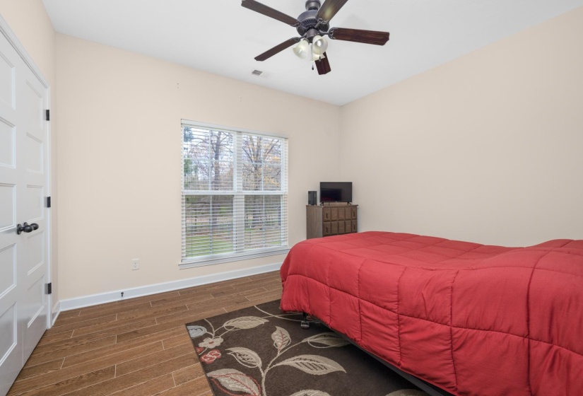 Bright room featuring wood-finish flooring and a ceiling fan with integrated lighting