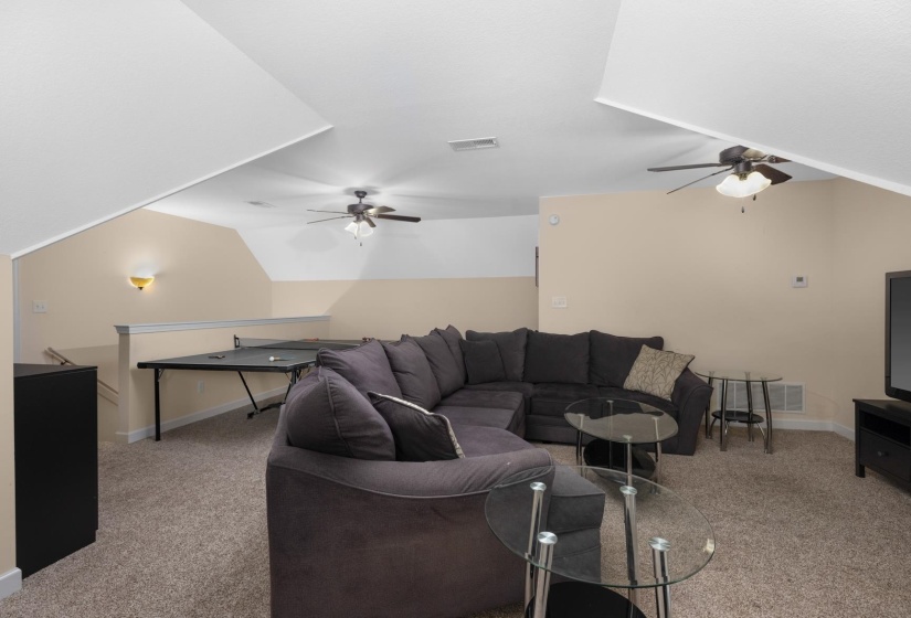 Spacious bonus room featuring sloped ceilings, carpet flooring, and neutral wall tones