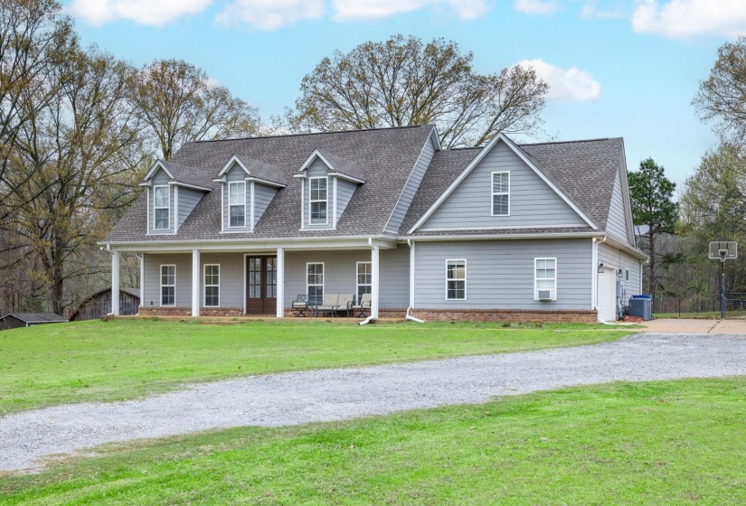 Gabled dormers and a full-width covered porch define this gray siding residence