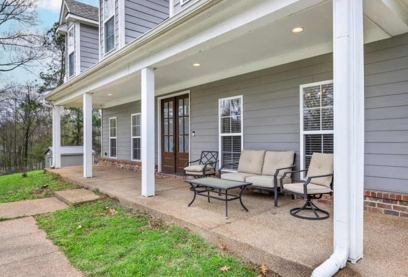 Columned front porch featuring a dark wood double-door entry