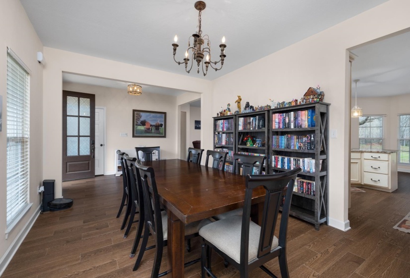 Spacious interior room featuring wood-finish flooring, a decorative chandelier, and light neutral wall colors