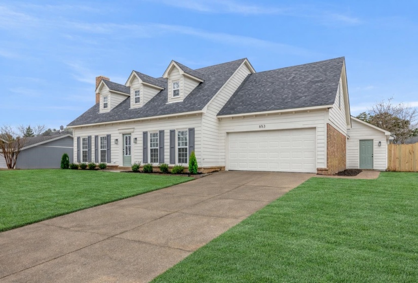 Classic white siding exterior with a dark shingle roof and three dormer windows