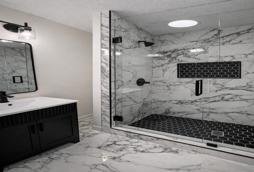 Contemporary bathroom featuring a walk-in shower with clear glass enclosure and black hexagonal tile floor
