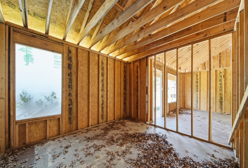 Interior framing with visible studs, ceiling joists, and roof trusses