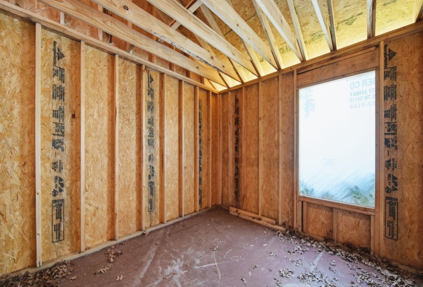 Interior framing featuring exposed wooden studs and oriented strand board sheathing