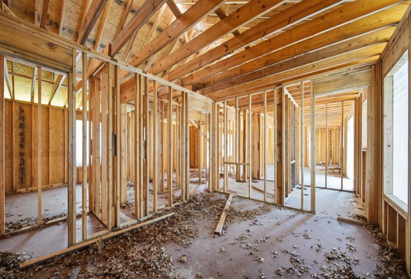 Interior construction framing showcasing exposed wooden studs and ceiling joists