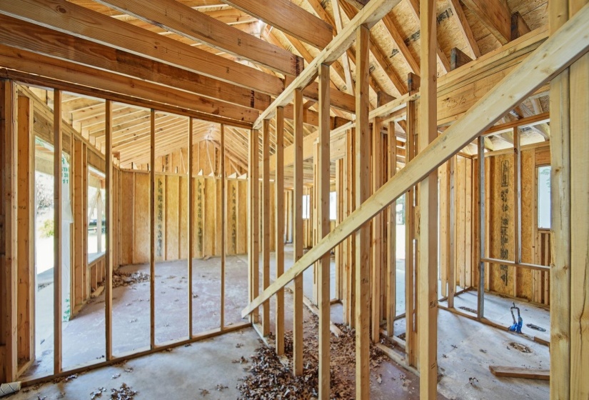 Open-concept interior framing with exposed timber trusses and structural walls