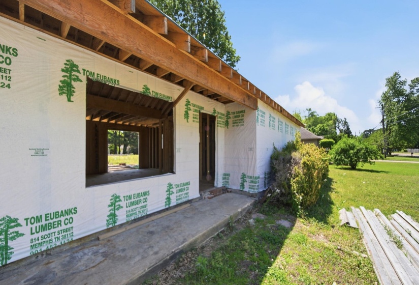 Framed construction featuring exposed roof rafters and window openings