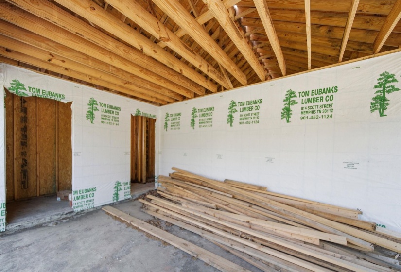 Exposed wooden ceiling trusses and wood wall framing