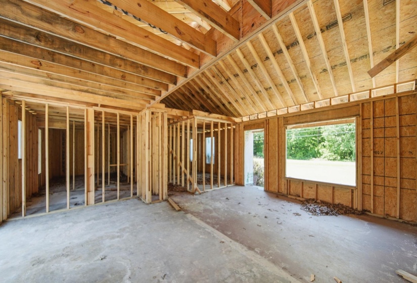 New construction framing featuring exposed wooden trusses and plywood sheathing