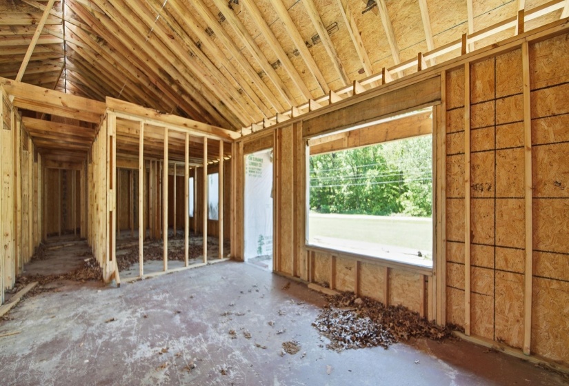 New construction framing featuring exposed wooden trusses and wall studs