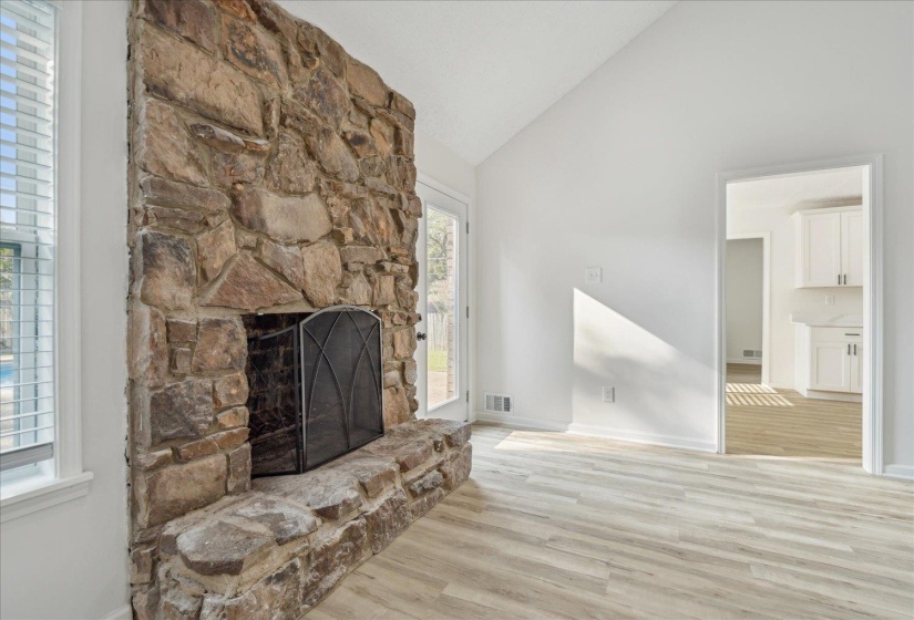 Floor-to-ceiling stone fireplace with a raised hearth