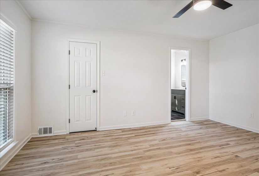 Room featuring wood-finish flooring, white walls, and a ceiling fan