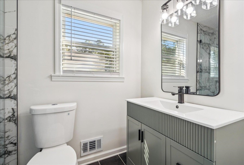 Modern bathroom featuring a contemporary vanity with an integrated sink, matte black faucet, and a sleek rectangular mirror